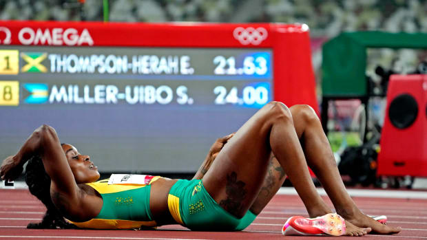 Elaine Thompson on the ground after defending her Olympic gold medal in the women's 200 meters.